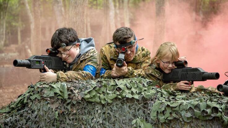 3 kids playing outdoor laser tag