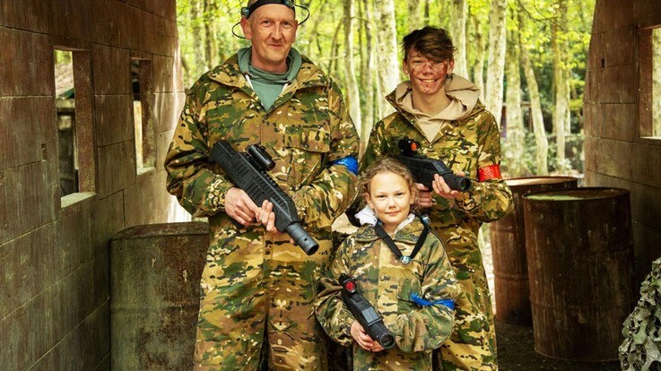 family holding laser quest guns