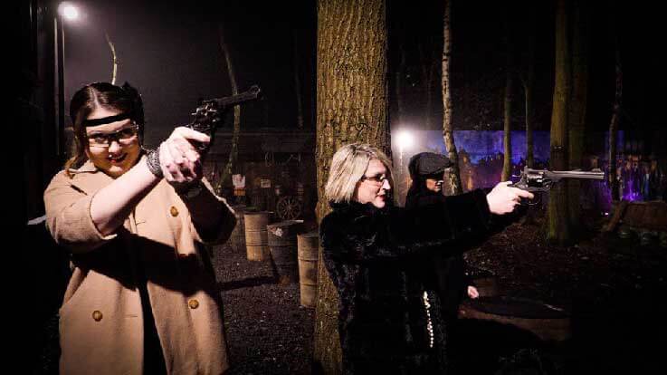 ladies in costume shooting pistols