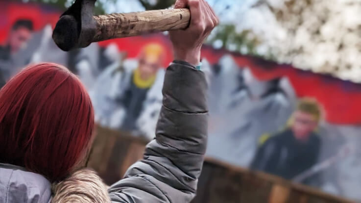 lady holding axe overhead ready to throw