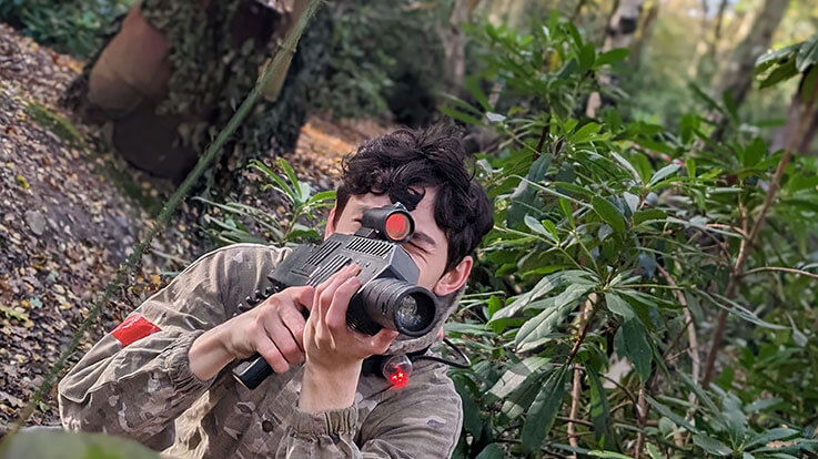 laser tag player hiding in wood cover