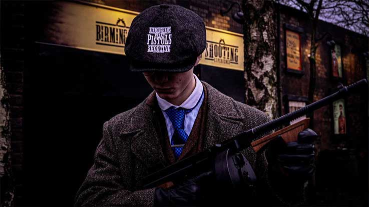 man dressed as gangster holding tommy gun