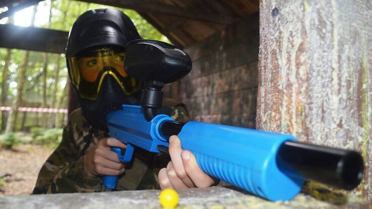 paintballer hiding behind cover