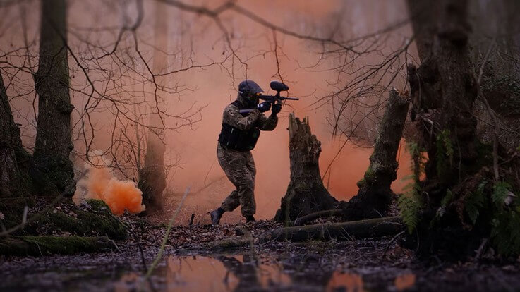 paintballer surrounded by smoke grenade cover