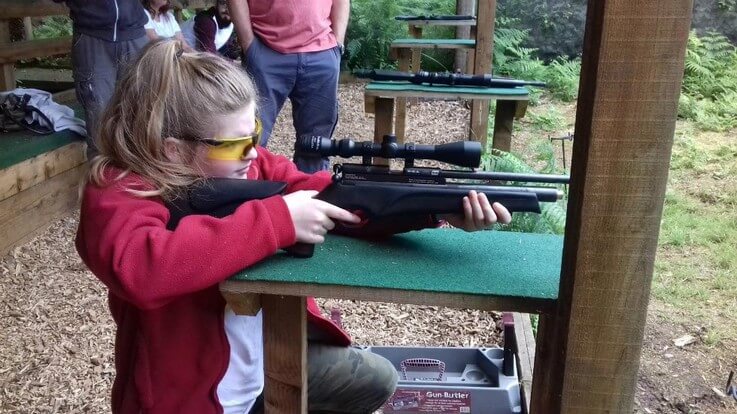young marksman aims rifle