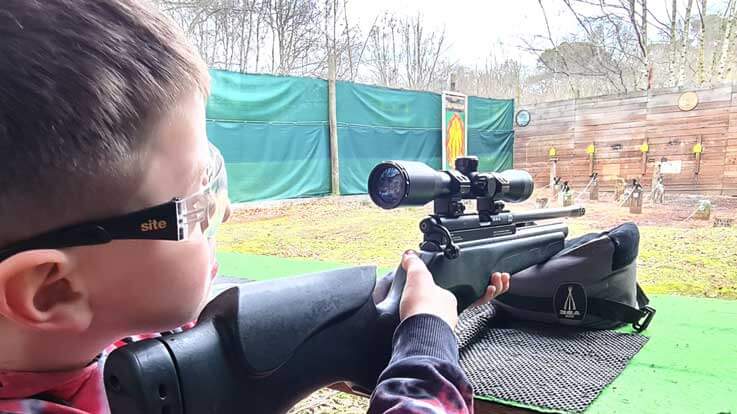 young marksman shouldering rifle