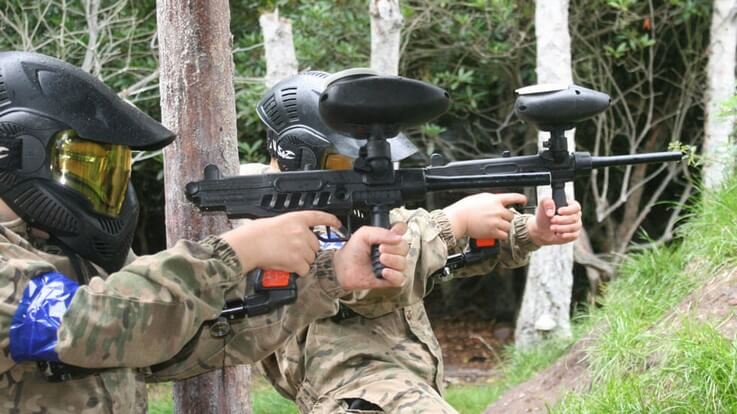 young players shooting paintballs